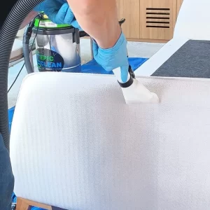 Especialista da Epic Clean realizando limpeza e extração em sofá.